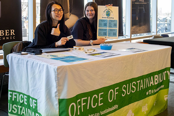 students sitting at a office of sustainability desk