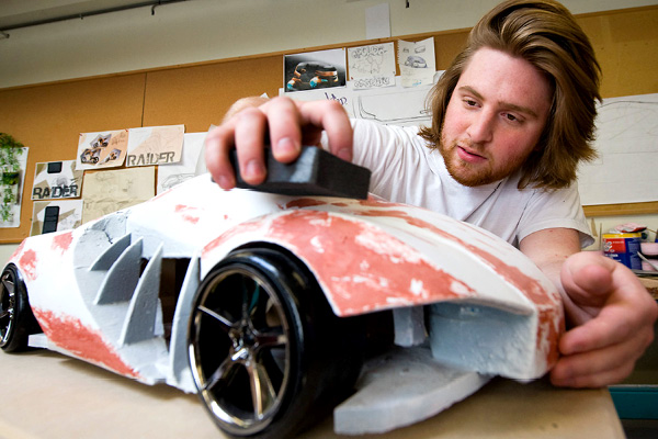 person working on physical 3D model of car