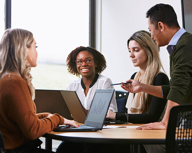 four people sitting at a table talking