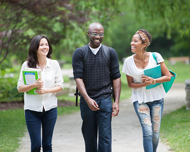 three people walking outside smiling and talking