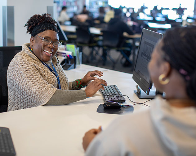 two people talking at a desk