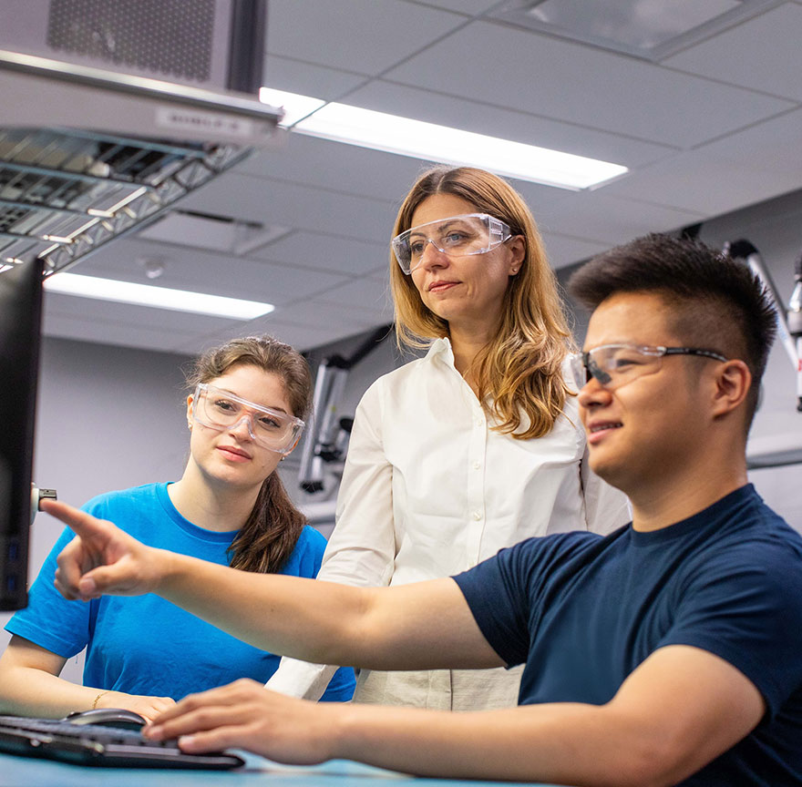 two students talking to a teacher