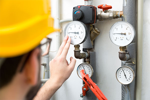 technician looking at gas gauge