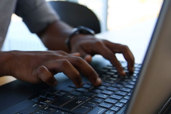 hands typing on laptop keyboard