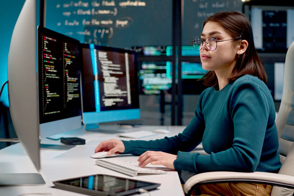 Person looking at computer screens with code