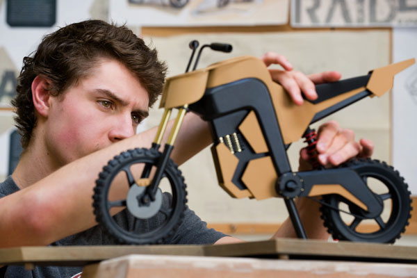 person working on physical scale model of motorcycle