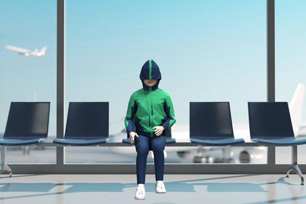 child sitting at the airport wearing cocoon with the hood over their face