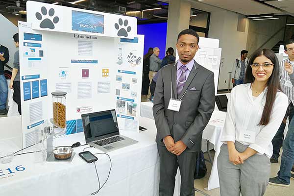 Students standing in front on Capstone Project display