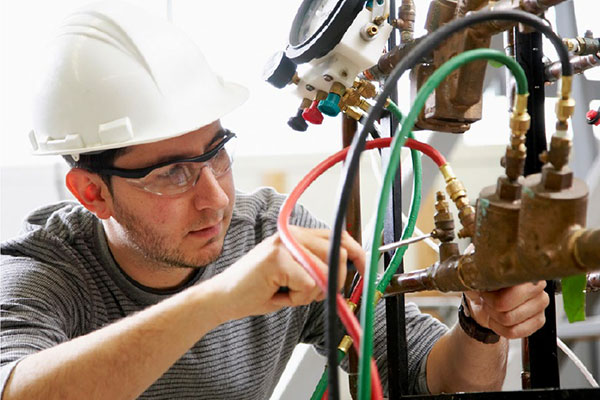 Plumber Apprenticeship - male working on pipes and lines