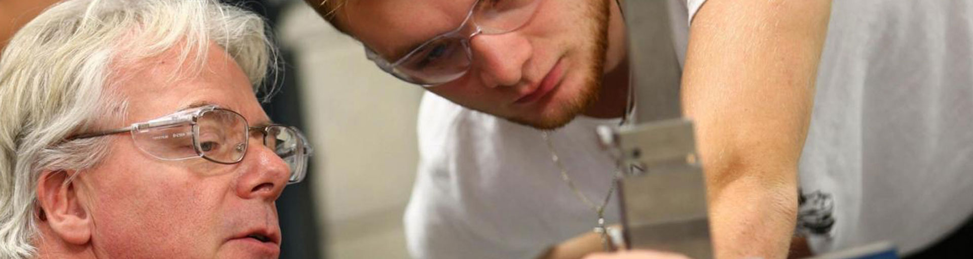 male teacher showing male student equipment