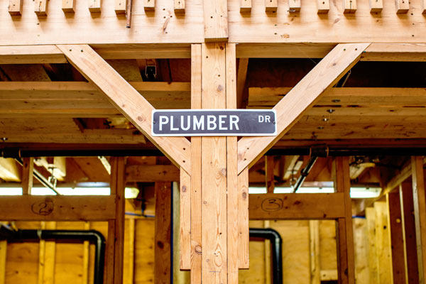 Wooden post with sign that read Plumber Drive