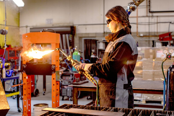 Person in sunglasses using torch inside welding facilities