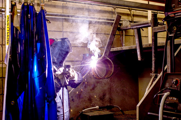 Person in welding mask welding large equipment