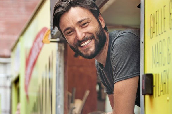 food truck owner smiling leaning out of the truck window