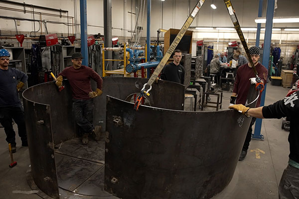 People holding big pieces of metal