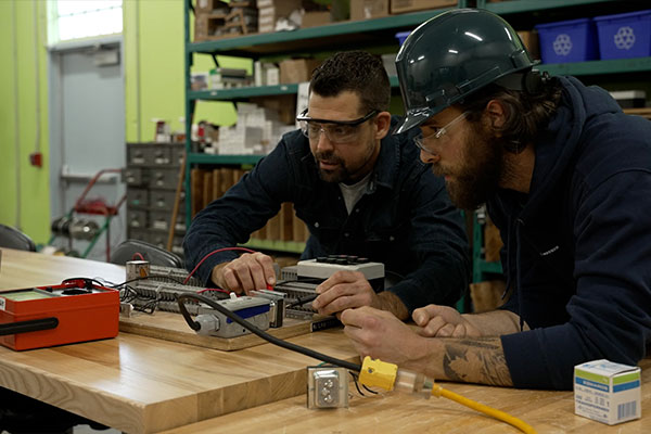 Two people working with wires