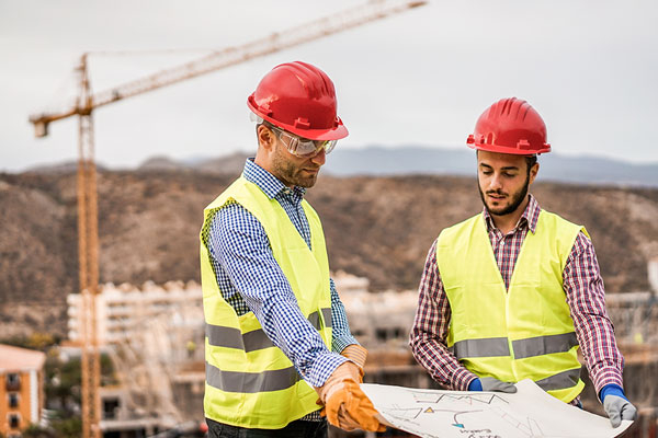 employer showing young worker a blueprint
